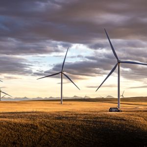 Sunset,Windmills,Producing,Green,Energy,On,A,Harvested,Wheat,Field