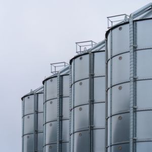 Stainless,Steel,Industrial,Silos,With,Overcast,Sky,Background.